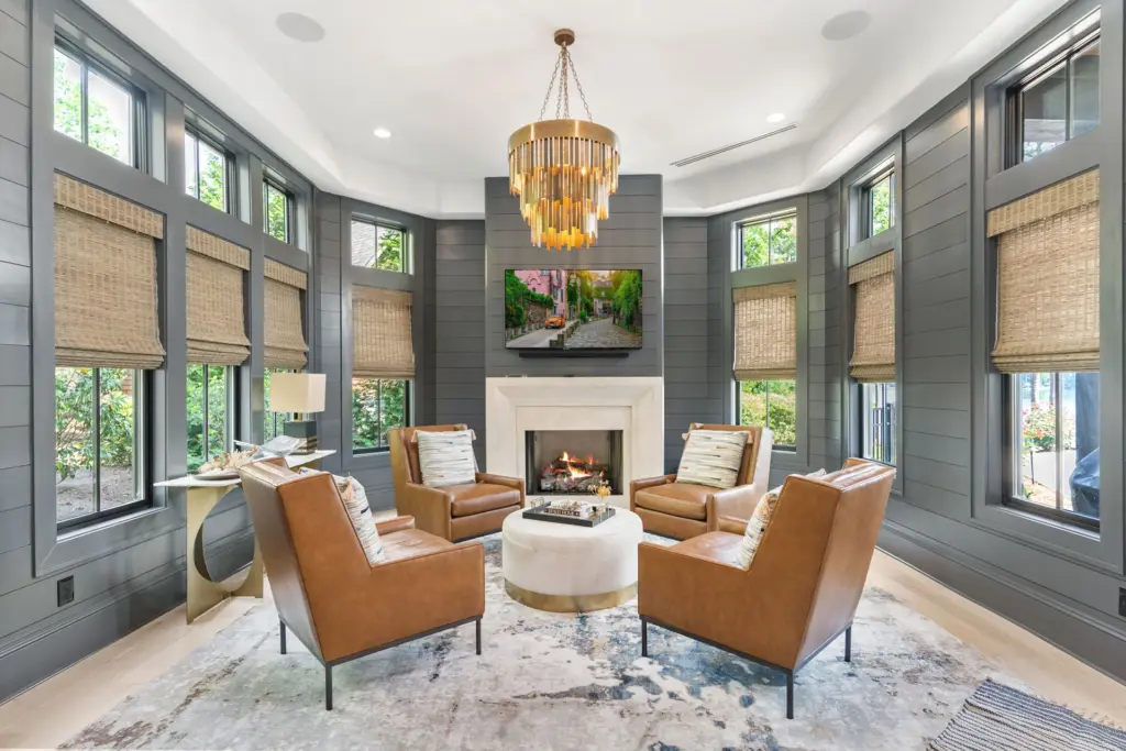 image shows a cozy, modern living room with a fireplace and large windows - custom home builder Southern Luxury Homes image shows a cozy, modern living room with a fireplace and large windows - custom home builder | Southern Luxury Homes