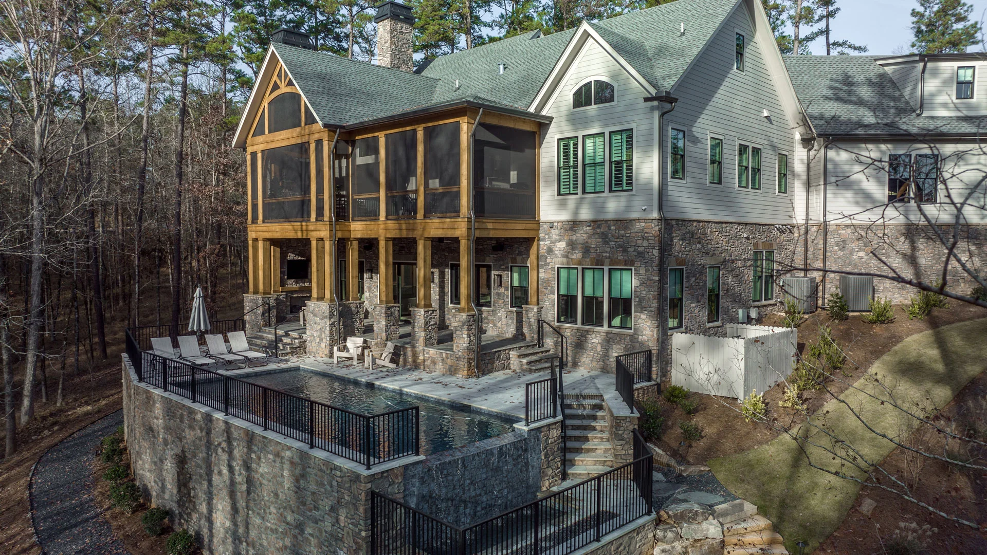 DJI_0782 Southern Luxury Homes image of arial exterior view of luxurious house with swimming pool and big windows on top - custom home builder | Southern Luxury Homes