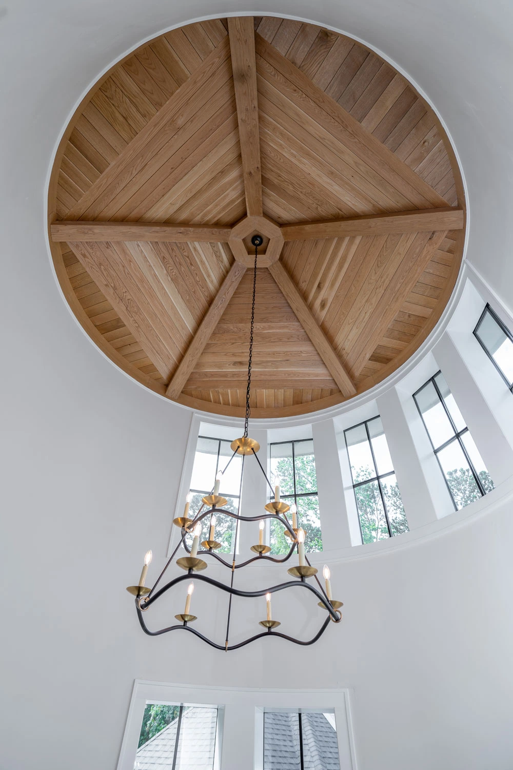 image of a circular wood-clad celing detail, with candle light chandelier - custom home builder