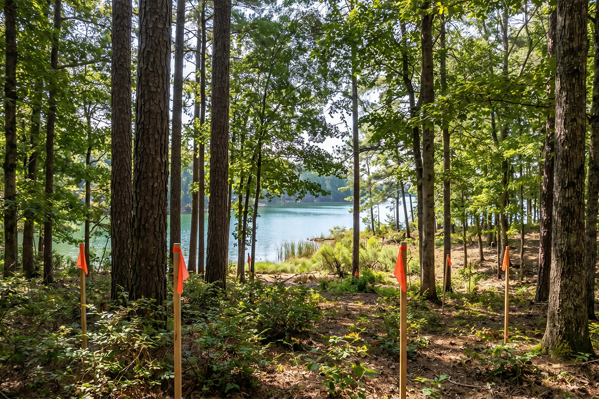 Wooded lakefront lot with survey markers ready for custom home building by Southern Luxury Homes